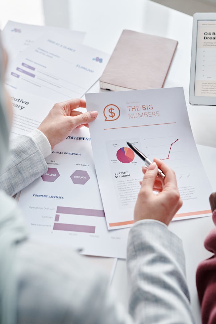Business team reviewing financial documents and data charts during a meeting session.